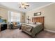 Cozy bedroom featuring a queen bed, a loveseat, and a ceiling fan at 16500 Quarter Horse Ct, Montverde, FL 34756