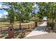 Scenic driveway lined with brick pillars and fencing, leading to a charming home nestled among trees at 16500 Quarter Horse Ct, Montverde, FL 34756