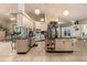 Open kitchen with black countertops, cream cabinets, and island, complemented by a unique pot rack and tiled floors at 16500 Quarter Horse Ct, Montverde, FL 34756