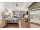 Bright bedroom with decorative tray ceiling, wood floors, and large attached bath at 16500 Quarter Horse Ct, Montverde, FL 34756