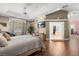 Bright bedroom with decorative tray ceiling, wood floors, and large attached walk-in closet at 16500 Quarter Horse Ct, Montverde, FL 34756