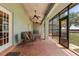 Covered porch with brick flooring, seating, ceiling fans, and a screened-in side at 16500 Quarter Horse Ct, Montverde, FL 34756