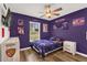 Cozy sports-themed bedroom with hardwood floors, ceiling fan, and decorative wall art and sports memorabilia at 1898 9Th Ave, Deland, FL 32724