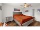 Well-lit bedroom features a queen-size bed, a nightstand, a ceiling fan, and hardwood floors at 1898 9Th Ave, Deland, FL 32724