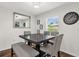 Bright dining area features a square table, gray upholstered chairs, a bench, and a stylish chandelier at 1898 9Th Ave, Deland, FL 32724