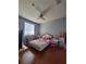 This bedroom boasts a fan, laminate flooring, and a pink bed with decorative pillows at 204 Terrace Ridge Cir # 204, Davenport, FL 33896