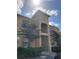 Inviting exterior of a two-story condo with a beige facade, front entry, and beautiful shrubbery at 204 Terrace Ridge Cir # 204, Davenport, FL 33896