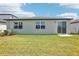 A view of the backyard with ample lawn space and a sliding glass door leading into the home at 2141 Rosewood Dr, Bartow, FL 33830