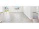 Open-concept living area featuring light wood-look flooring, and entry to additional room at 2141 Rosewood Dr, Bartow, FL 33830