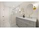 Bright bathroom with a double sink vanity, a shower with a tile surround, and elegant gold fixtures at 2327 Fieldingwood Rd, Maitland, FL 32751