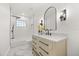 Chic bathroom featuring a tiled shower with a glass block window and vanity with a white countertop at 2327 Fieldingwood Rd, Maitland, FL 32751