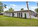 Side view of home featuring well-kept lawn, an arched front door, arched windows, and a one car garage at 2327 Fieldingwood Rd, Maitland, FL 32751