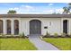 Close up of the arched front door with manicured landscaping and new exterior paint at 2327 Fieldingwood Rd, Maitland, FL 32751