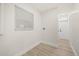 Laundry room featuring light wood floors, a window with blinds, and white walls at 2327 Fieldingwood Rd, Maitland, FL 32751
