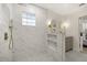 Modern bathroom featuring a tiled shower with gold fixtures, a glass block window, and stylish gray vanity at 2327 Fieldingwood Rd, Maitland, FL 32751
