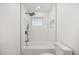 Modern tub and shower with black fixtures, a tiled surround, and a glass block window at 2327 Fieldingwood Rd, Maitland, FL 32751