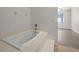 Bathroom featuring a large soaking tub, tile flooring and light gray flooring in the adjacent room at 242 Coco Plum Dr, Davenport, FL 33897