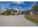 A paved entryway to community clubhouse with tropical landscaping at 242 Coco Plum Dr, Davenport, FL 33897