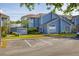 Charming two-story townhouse with blue siding, manicured lawn, and convenient parking spaces at 242 Coco Plum Dr, Davenport, FL 33897