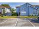 Charming two-story townhouse with blue siding, manicured lawn, and convenient parking spaces at 242 Coco Plum Dr, Davenport, FL 33897