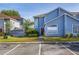 Charming two-story townhouse with blue siding, manicured lawn, and convenient parking spaces at 242 Coco Plum Dr, Davenport, FL 33897