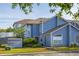 Charming two-story townhouse with blue siding, manicured lawn, and convenient parking spaces at 242 Coco Plum Dr, Davenport, FL 33897