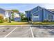 Charming two-story townhouse with blue siding, manicured lawn, and convenient parking spaces at 242 Coco Plum Dr, Davenport, FL 33897