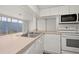 Bright kitchen features white cabinets, modern appliances, and a double sink with sliding door access to the lanai at 242 Coco Plum Dr, Davenport, FL 33897