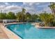 Community pool with clear water, surrounded by lounge chairs and lush landscaping for relaxation and enjoyment at 242 Coco Plum Dr, Davenport, FL 33897