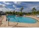 Sparkling community pool featuring clear blue water and convenient access steps, surrounded by beautiful landscaping at 242 Coco Plum Dr, Davenport, FL 33897
