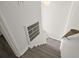 Stairway with laminate floors and a handrail on the wall. The stairs are next to a white wall with air vent at 242 Coco Plum Dr, Davenport, FL 33897