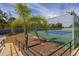 An outdoor tennis court is enclosed with a fence and green surroundings at 242 Coco Plum Dr, Davenport, FL 33897