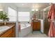 Bright bathroom featuring dual sinks, a corner tub, and a glass enclosed shower at 2420 Heron Ct, St Cloud, FL 34769