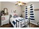Nautical-themed bedroom featuring a comfortable bed, ceiling fan, and plenty of natural light at 2420 Heron Ct, St Cloud, FL 34769