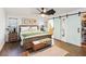 A calming main bedroom with a wooden bed frame, sliding barn doors, and an ensuite bathroom at 2420 Heron Ct, St Cloud, FL 34769