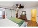 Calming main bedroom with wood floors, a modern ceiling fan, and sliding barn doors to the walk-in closet at 2420 Heron Ct, St Cloud, FL 34769
