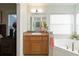 Relaxing bathroom featuring a soaking tub, vanity with sink, and decorative accents at 2420 Heron Ct, St Cloud, FL 34771