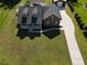 An aerial view of a well-maintained home with a lush green lawn and a long driveway at 2420 Heron Ct, St Cloud, FL 34771