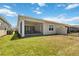 Grassy backyard featuring a screened patio, perfect for outdoor relaxation and entertaining at 2423 Datura Loop, St Cloud, FL 34772
