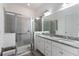 Bathroom showcasing granite countertops, double sinks, a glass enclosed shower, and ample vanity space at 2423 Datura Loop, St Cloud, FL 34772