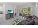 Bright living room with tile floors, comfortable seating, and sliding glass doors to the screened patio at 2423 Datura Loop, St Cloud, FL 34772