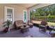 This screened patio offers a cozy seating area with wicker furniture and lovely landscaping at 2423 Datura Loop, St Cloud, FL 34772