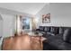 Bright living room featuring hardwood floors, a comfortable black leather sofa, and lots of natural light at 2504 London Bridge Ct, Orlando, FL 32837