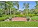 Beautifully landscaped backyard with brick patio, mature trees, and manicured lawn for outdoor enjoyment at 2610 Cloudcroft Dr, Apopka, FL 32703