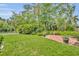 Lush backyard with mature trees, manicured lawn, plants and custom paved patio area at 2610 Cloudcroft Dr, Apopka, FL 32703