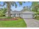 Charming single-story home with a well-manicured lawn, mature tree, and an attached two-car garage at 2610 Cloudcroft Dr, Apopka, FL 32703