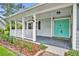 Inviting front porch with a teal door, white railings, and decorative landscaping at 2610 Cloudcroft Dr, Apopka, FL 32703
