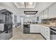 Bright kitchen featuring white cabinets, stainless steel appliances, and a stylish backsplash at 2610 Cloudcroft Dr, Apopka, FL 32703
