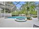 The pristine pool has an attached spa surrounded by lush landscaping in a screened enclosure at 2610 Cloudcroft Dr, Apopka, FL 32703