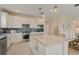 Spacious kitchen featuring granite countertops, modern appliances, a large island, and stylish pendant lighting at 2745 Serenity Meadow Dr, Kissimmee, FL 34744